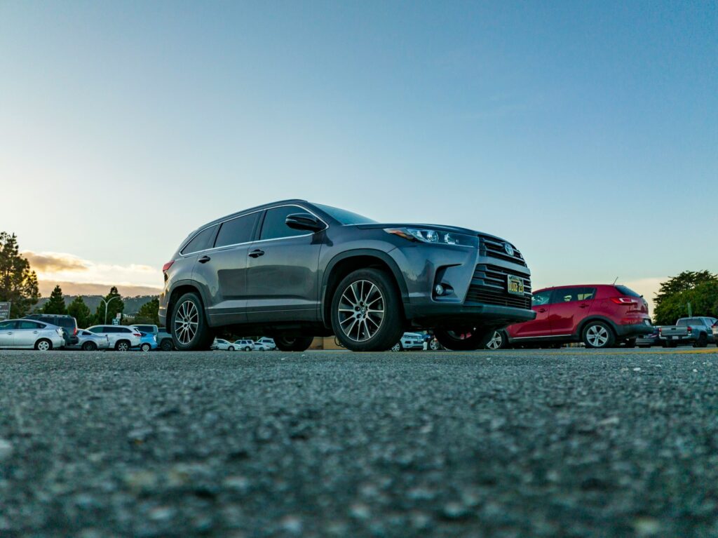 a gray suv parked in a parking lot next to a red car